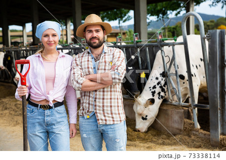 Successful farm family in cowshed 73338114