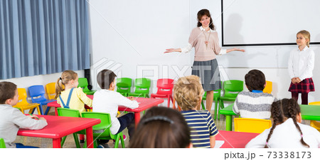 Teacher near whiteboard with schoolgirl Teacher near whiteboard with schoolgirl 73338173