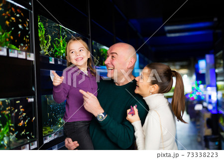 Friendly family searching exotic fish for home fish tank 73338223