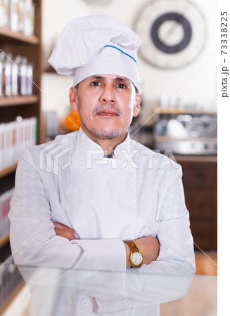 Portrait of middle aged man baker with tasty cakes smiling in bakery 73338225