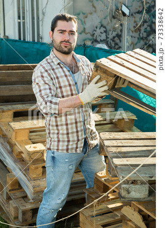 Man laying wooden pallets 73338642