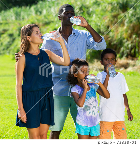 Family drinking water in park 73338701