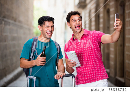Men tourists with beer are making selfie in unknown city. Men tourists with beer are making selfie in unknown city. 73338752