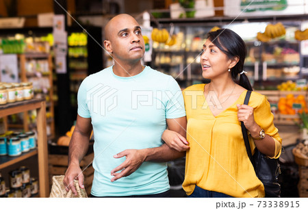 Latin american family couple shopping in food department of supermarket Latin american family couple shopping in food department of supermarket 73338915