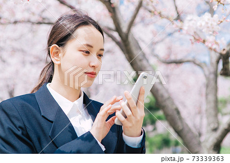 桜とスーツの若い女性 73339363