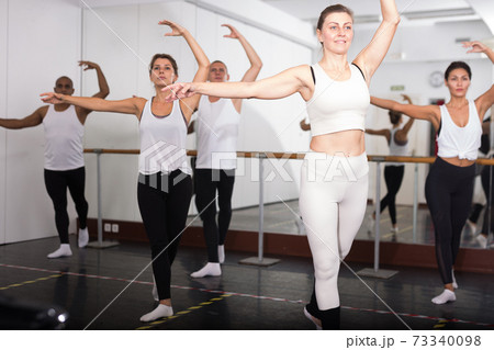 Sporty guys and girls performing dance elements 73340098