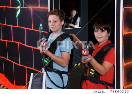 Two joyful teen boys standing with laser guns 73340219