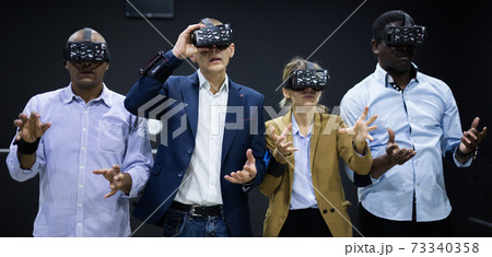 People using virtual reality glasses delighted with videogames People using virtual reality glasses delighted with videogames 73340358