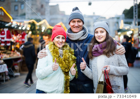 Portrait of family couple with teen girl at Christmas fair 73341049