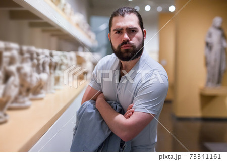 Man looking at stone architectural elements in historical museum hall Man looking at stone architectural elements in historical museum hall 73341161