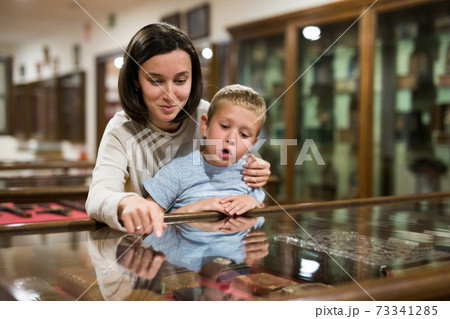 Woman and boy exploring artworks in museum 73341285