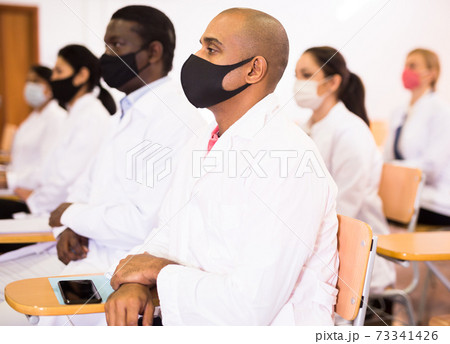 Hispanic doctor in protective mask attending medical congress 73341426