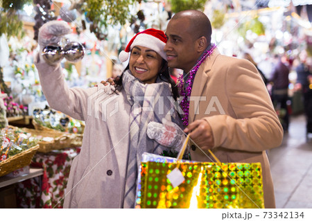 Emotional happy couple buying christmas balls at christmas fair 73342134