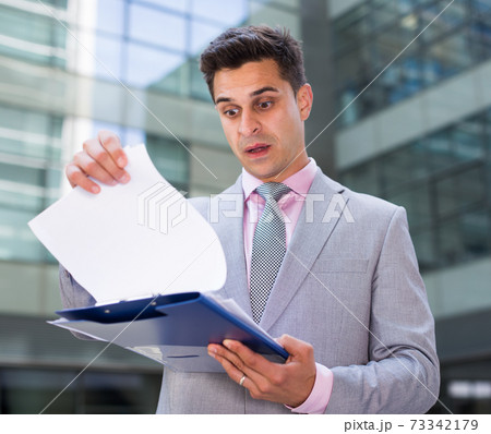 Shocked businessman reading documents 73342179