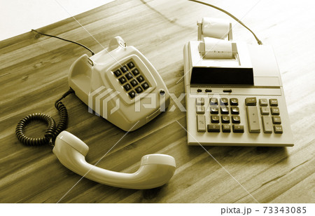 Old fashioned calculator and telephone Old fashioned calculator and telephone 73343085