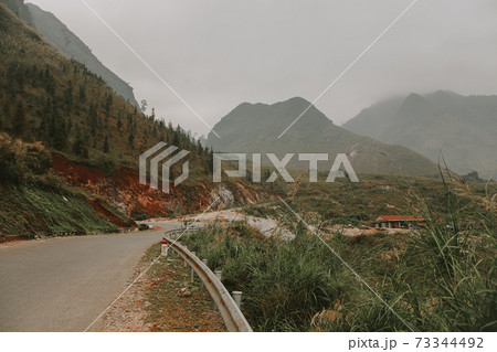 Cinematic foggy winding road to the karst mountains in Meo vac District, Ha giang Vietnam 73344492