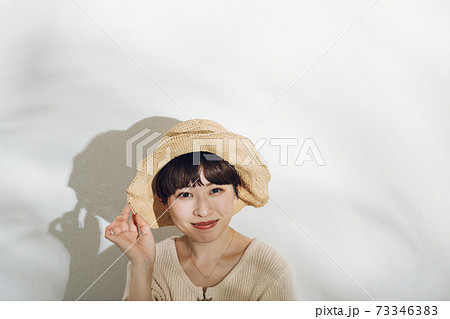 麦わら帽子のショートヘアの女性 代 若い女性イメージの写真素材
