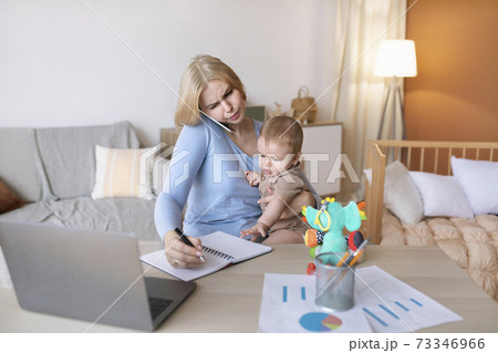 Busy mother with baby on her lap having phone conversation Busy mother with baby on her lap having phone conversation 73346966