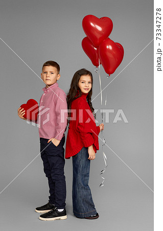 couple of little girl and boy with red heart balloons couple of little girl and boy with red heart balloons 73347278
