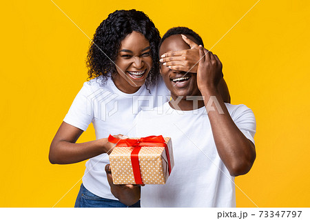 Cheerful african woman making Valentine surptise for her husband 73347797