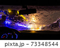 frosted car glass. snow covered car windshield. view from inside the car on the night city 73348544