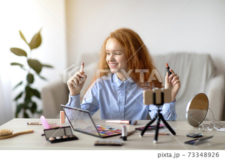 Red-Haired Teen Girl Recording Her Beauty Blog, Choosing Lipstick Red-Haired Teen Girl Recording Her Beauty Blog, Choosing Lipstick 73348926