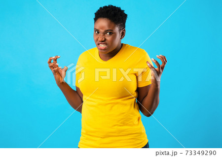 Mad African Woman Freaking Out Looking Angrily Posing, Blue Background 73349290