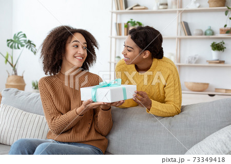 Happy sisters exchanging gifts on holiday, new year or birthday 73349418