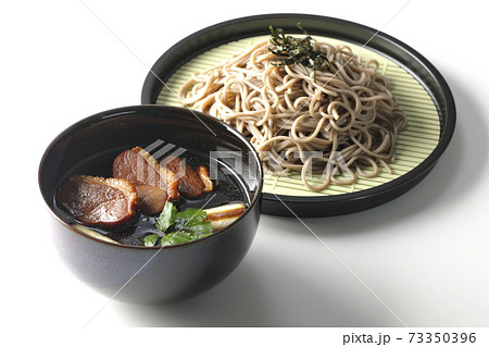 ロースト鴨肉と焼長葱と三つ葉の入った鴨せいろ蕎麦を白背景で撮影 73350396