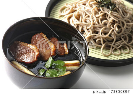 ロースト鴨肉と焼長葱と三つ葉の入った鴨せいろ蕎麦を白背景で撮影 73350397