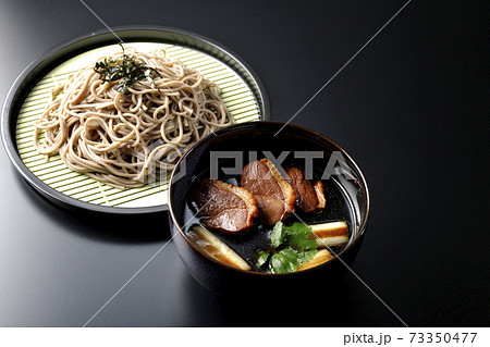 ロースト鴨肉と焼長葱と三つ葉の入った鴨せいろ蕎麦を黒背景で撮影 ロースト鴨肉と焼長葱と三つ葉の入った鴨せいろ蕎麦を黒背景で撮影 73350477