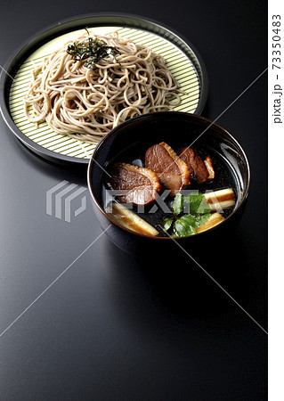 ロースト鴨肉と焼長葱と三つ葉の入った鴨せいろ蕎麦を黒背景で撮影 ロースト鴨肉と焼長葱と三つ葉の入った鴨せいろ蕎麦を黒背景で撮影 73350483
