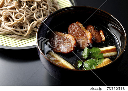 ロースト鴨肉と焼長葱と三つ葉の入った鴨せいろ蕎麦を黒背景で撮影 ロースト鴨肉と焼長葱と三つ葉の入った鴨せいろ蕎麦を黒背景で撮影 73350518