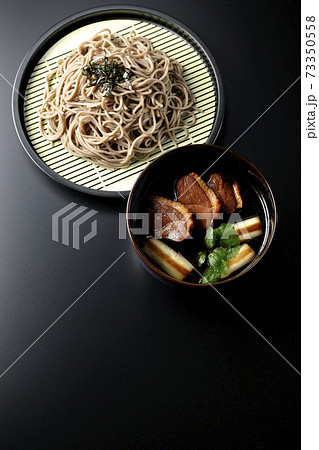 ロースト鴨肉と焼長葱と三つ葉の入った鴨せいろ蕎麦を黒背景で撮影(俯瞰) ロースト鴨肉と焼長葱と三つ葉の入った鴨せいろ蕎麦を黒背景で撮影(俯瞰) 73350558
