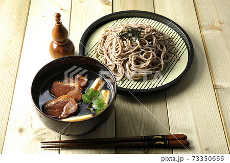 ロースト鴨肉と焼長葱と三つ葉の入った鴨せいろ蕎麦と瓢箪型の七味入れと箸 73350666