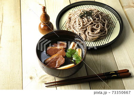 ロースト鴨肉と焼長葱と三つ葉の入った鴨せいろ蕎麦と瓢箪型の七味入れと箸 73350667
