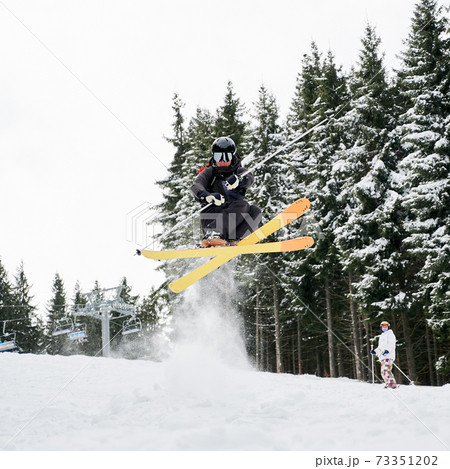Young man on skis doing tricks at ski resort. 73351202
