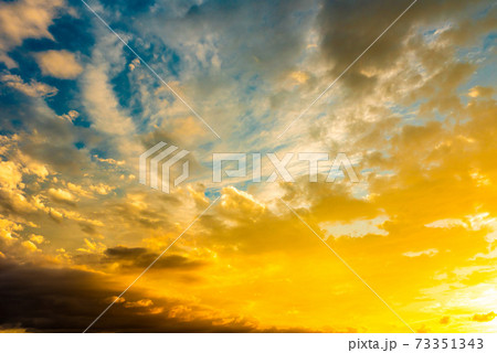 綺麗な夕焼けの染まる雲と空 背景素材 青色強調色濃いめの写真素材