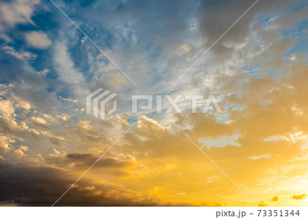 綺麗な夕焼けの染まる雲と空 背景素材 青色強調の写真素材