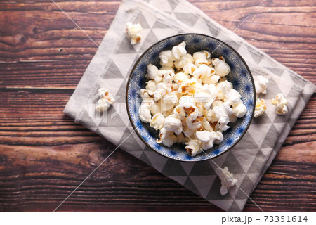 popcorn in a bowl on wooden desk 73351614