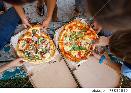 Group of children with pizza in the open box 73352619