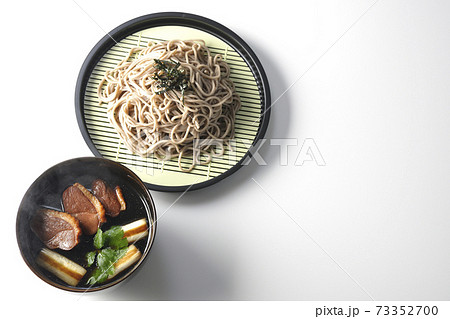 ロースト鴨肉と焼長葱と三つ葉の入った熱々の鴨せいろ蕎麦を白背景で撮影（俯瞰） 73352700