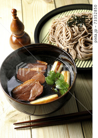 ロースト鴨肉と焼長葱と三つ葉の入った熱々の鴨せいろ蕎麦と瓢箪型の七味入れと箸 73352850
