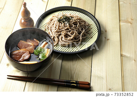 ロースト鴨肉と焼長葱と三つ葉の入った熱々の鴨せいろ蕎麦と瓢箪型の七味入れと箸 ロースト鴨肉と焼長葱と三つ葉の入った熱々の鴨せいろ蕎麦と瓢箪型の七味入れと箸 73352852