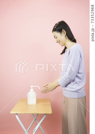 アルコール消毒をする女性 73352968