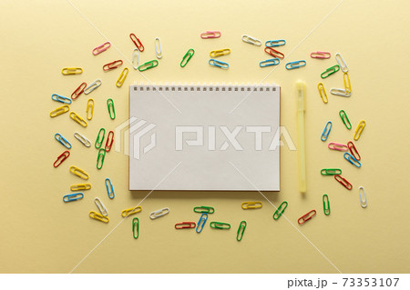 Open spiral notepad on yellow background 73353107