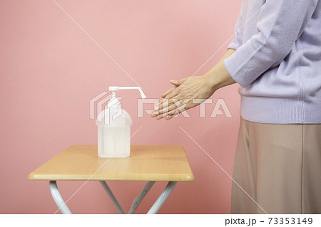 アルコール消毒をする女性の手元 73353149
