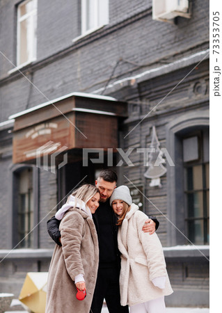 beautiful family with dog on a leash on street. photo shoot. beautiful family with dog on a leash on street. photo shoot. 73353705