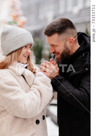 Dad and daughter walk winter streets and warms her hands with breath. Dad and daughter walk winter streets and warms her hands with breath. 73353711