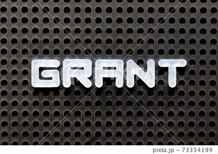White color alphabet with word grant on black pegboard background 73354199
